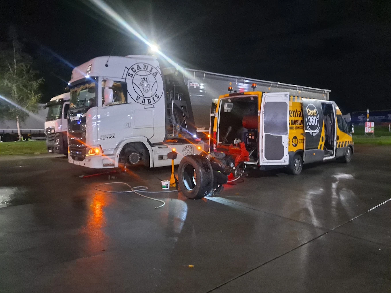 Nocna naprawa opony ciężarówki Scania na parkingu